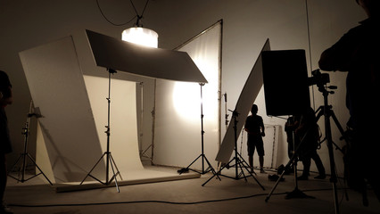 Silhoutte images of video production and lighting set for filming which movie crew team working and...