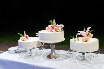 Three wedding cakes with a fresh lillium flower decoration.