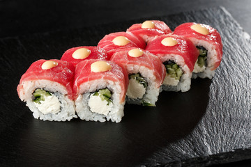 Sushi Rolls with cucumber, tuna, and Cream Cheese inside on black slate isolated. Philadelphia roll sushi with shrimp. Sushi menu. Horizontal photo.