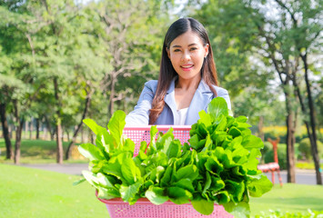 Asian beautiful business woman show the basket of vegetable and present in front of her that relate to green business concept.