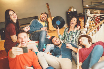 Happy friends taking selfie with mobile smartphone camera at home - Group young people having fun...