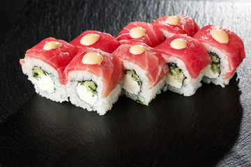 Sushi Rolls with cucumber, tuna, and Cream Cheese inside on black slate isolated. Philadelphia roll sushi with shrimp. Sushi menu. Horizontal photo.
