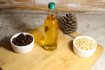 golden cedar oil in bottle , cone, nuts on wooden background