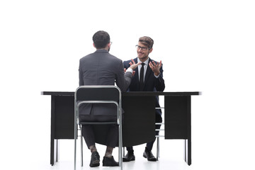 two businessmen talking, sitting at his Desk