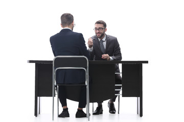 two businessmen talking, sitting at his Desk