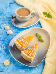 Two pieces of traditional american pumpkin pie with cup of coffee on a blue concrete background. side view, close up