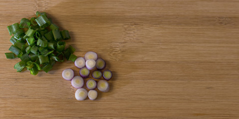 Fototapeta premium Cebollitas de Verdeo sobre tabla de cocina. Preparando la cena. Cocinando. Verduras frescas. 