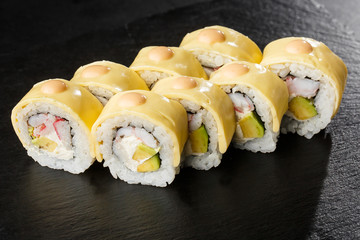 Sushi Rolls with processed cheese, cheddar, american cheese, avocado, crab meat, shrimp and Cream Cheese inside on black slate isolated. Philadelphia roll sushi with shrimp. Sushi menu. Horizontal.