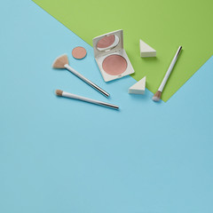 Fashion beauty product layout. Woman Essentials cosmetic makeup Set. Collection beauty accessories. Trendy Brushes, lipstick. Coloful green blue art Flat lay. Creative make up artist concept