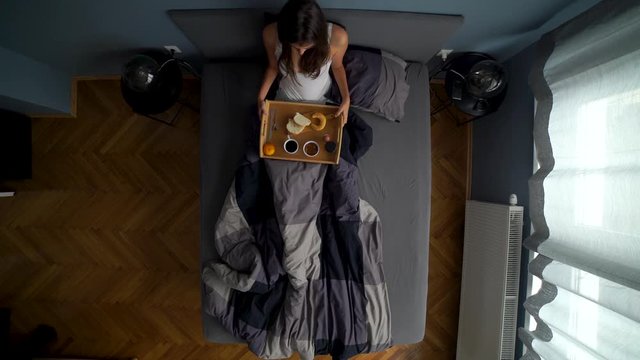Image from above of attractive brunette woman getting breakfast alone.