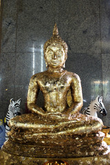 Buddha statue with gold leaf attached to the whole body