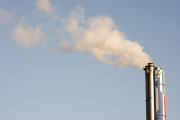 Industrial chimney with emission, with a clear blue sky