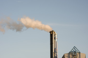 Industrial chimney with emission, with a clear blue sky