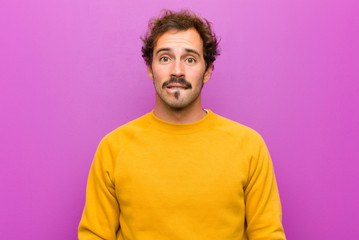 young handsome man feeling clueless, confused and uncertain about which option to pick, trying to...