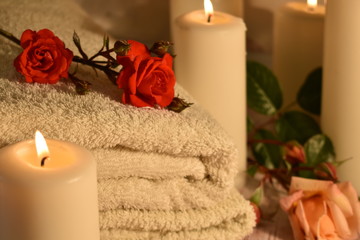 Fototapeta na wymiar The concept of spa salon and bath. Towel, roses and candles. Relaxation and enjoyment at the spa hotel.