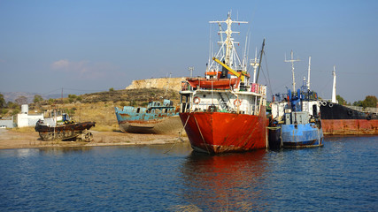 Fototapeta premium Old abandoned shipyard with scrap boats left to rust in Elefsina area, Attica, Greece