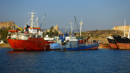 Fototapeta premium Old abandoned shipyard with scrap boats left to rust in Elefsina area, Attica, Greece