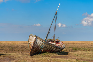 An old wooden sailing boat in Thornham Old Harbour, Norfolk, England, UK