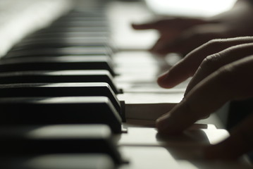 children's hands are playing the piano © taraskobryn