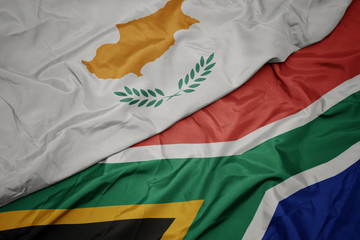 waving colorful flag of south africa and national flag of cyprus.