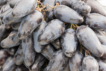 A bunch of blue grapes lies on the window of a market, store, supermarket