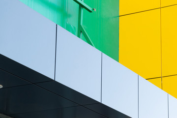Geometric color elements of the building facade with planes, lines, corners with highlights and reflections for an abstract background and texture of gray, green, yellow colors. Place for text