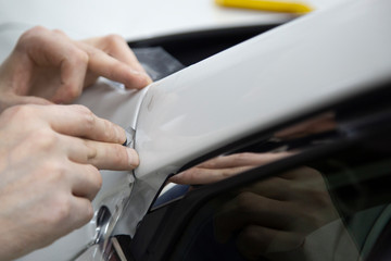 Installation of protective film for car paint.Professional installation of protective film on the car body.