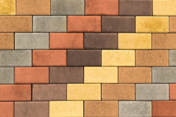 Paving slabs, stones of rectangular and square shapes of different colors laid out with patterns for equipping paths in the country as a background or texture