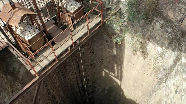 Aerial drone video of a deep shaft and the mining machinery of an ancient gold and silver mine
