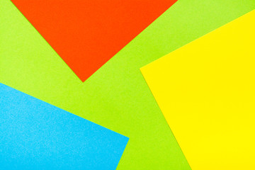 Four-color yellow green red blue abstract cardboard background. Sheets of cardboard are stacked on top of each other. Copy space