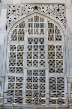 Beautifully designed marble arch window with details ornaments and colorful gems of the Taj Mahal. Taj Mahal built-in 1643 by Mughal emperor Shah Jahan to house the tomb of his wife Mumtaz Mahal.