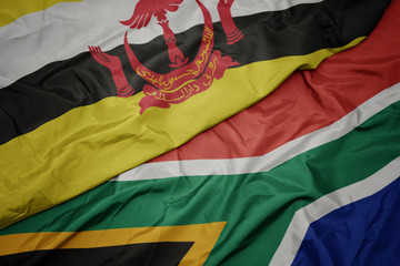 waving colorful flag of south africa and national flag of brunei.