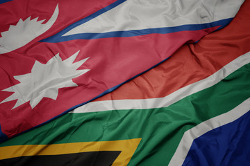 waving colorful flag of south africa and national flag of nepal.