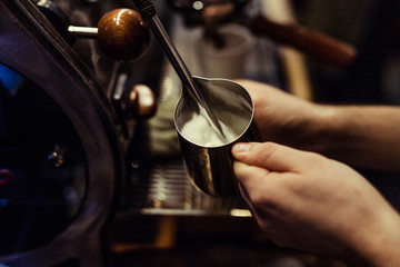 Fototapeta na wymiar Barista making coffee in coffee shop, hands holding cup of coffee.