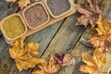 Spices in wooden bowls with autumn decorations on the wooden table