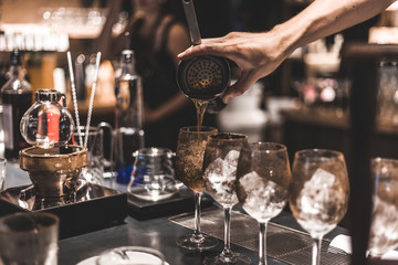 Bartender making cocktails at the bar, alcoholic drinks  