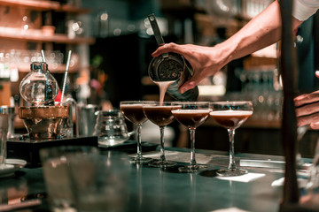 Bartender making cocktails at the bar, alcoholic drinks  