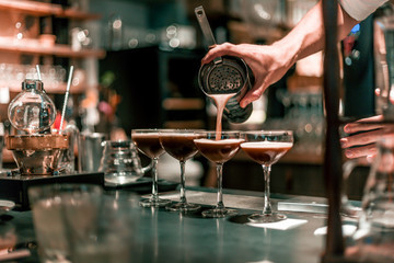 Bartender making cocktails at the bar, alcoholic drinks  