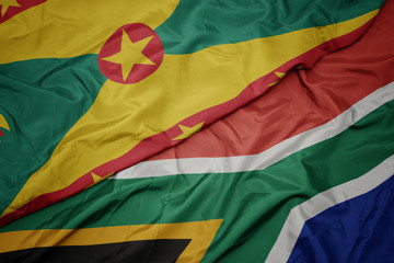 waving colorful flag of south africa and national flag of grenada.