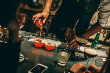 Bartender making cocktails at the bar, alcoholic drinks  