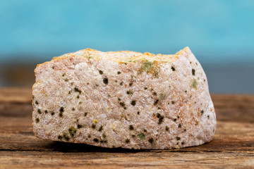 Moldy dry slice of bread on a wooden surface and blue background_