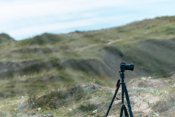 camera on tripod on sea coast cliff