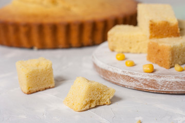 Slices of freshly baked corn bread on a white table.