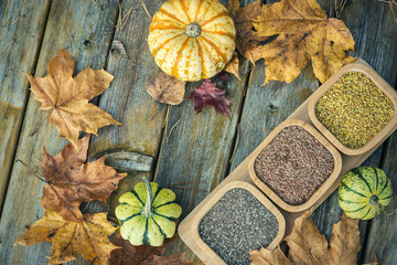 Spices in wooden bowls with autumn decorations on the wooden table