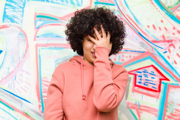 young pretty afro woman laughing and slapping forehead like saying d‚Äôoh! I forgot or that was...