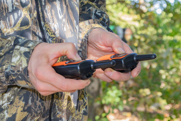 Portable radios in human hands and on clothing items