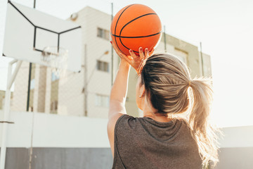 Young female basketball player training outdoors on a local court