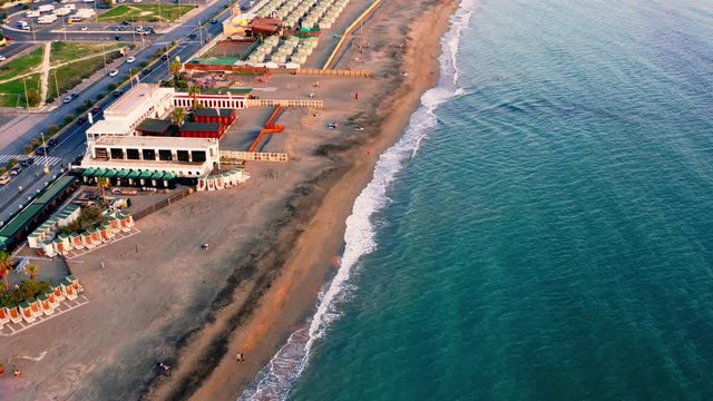 Flying on drone above Ostia beach in Italy in warm autumn evening, aerial view