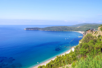 Fototapeta na wymiar Panoramic view from above to the Adriatic sea coastline and Jaz beach near a Budva city, Montenegro. The concept of summer holidays and travel.