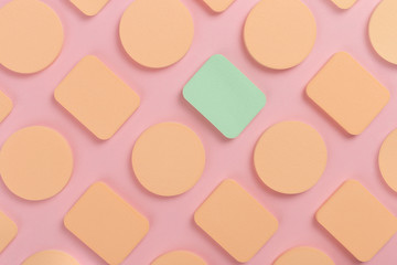 A lot of sponge, a beautiful blender for applying foundation or powder. Flat lay on a pink background, copy space.
